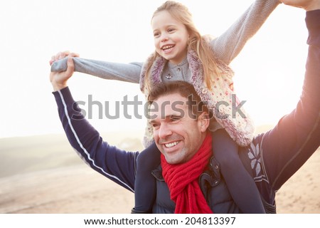 Father And Daughter Walking On Winter Beach