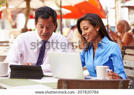 Two Businesspeople Having Meeting In Outdoor Cafe
