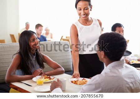 Waitress Serving Couple Breakfast In Hotel Restaurant