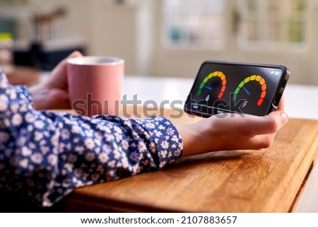 Close Up Of Woman Holding Smart Energy Meter In Kitchen Measuring Domestic Electricity And Gas Use ストックフォト © 