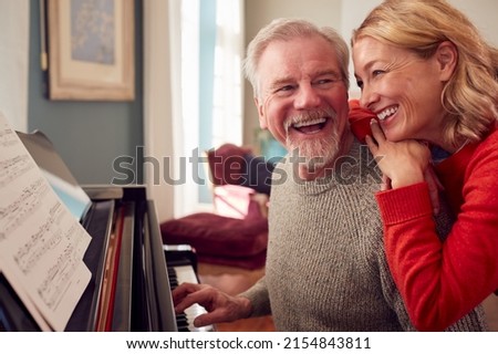 Similar – Image, Stock Photo Smiling woman playing piano in living room