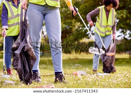 Close Up Of Female Volunteers Picking Up Litter In The Countryside Foto stock © 