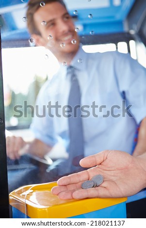 Close Up Of Hand Giving Driver Fare For Bus Journey