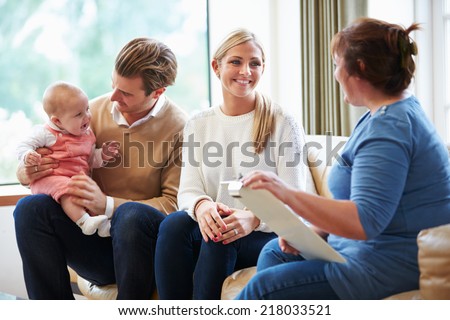 Health Visitor Talking To Family With Young Baby