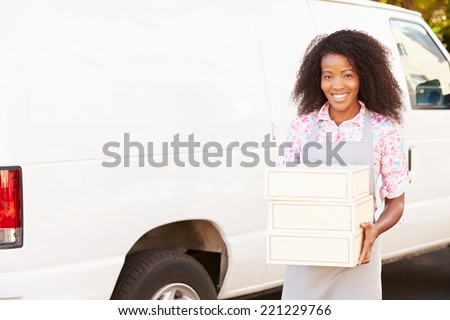 Female Baker Unloading Cakes From Van