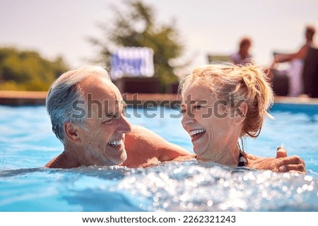 Similar – Image, Stock Photo Mature couple swimming together in fresh water