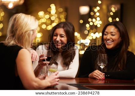 Group Of Female Friends Enjoying Evening Drinks In Bar
