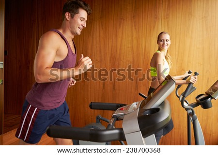 Couple Exercising Together In Home Gym