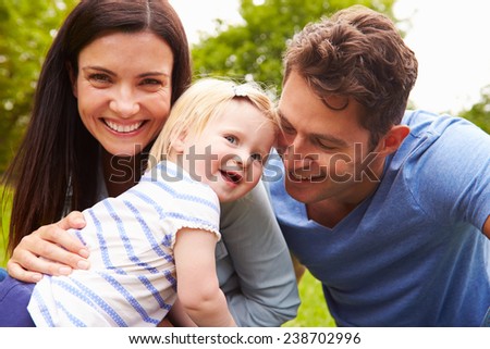 Portrait Of Family Playing Game In Garden With Daughter