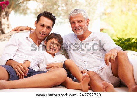 Grandfather,Father And Grandson Sitting Outdoors At Home