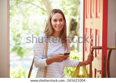 Young Woman Returning Home For Work With Shopping