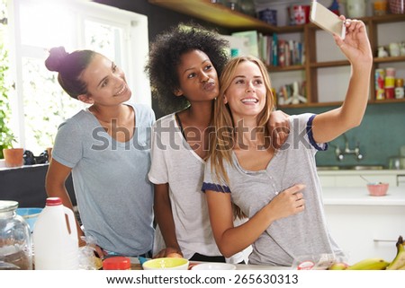 Three Female Friends Taking Selfie Whilst Making Breakfast