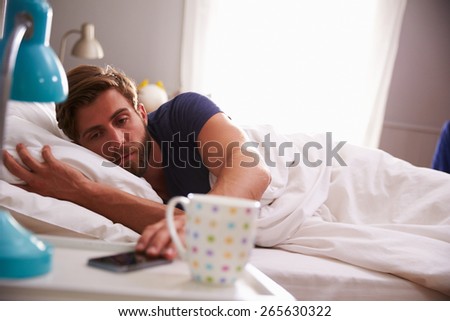 Sleeping Man Being Woken By Mobile Phone In Bedroom