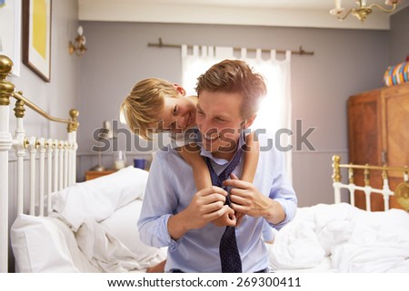 Son Hugging Father As He Gets Dressed For Work
