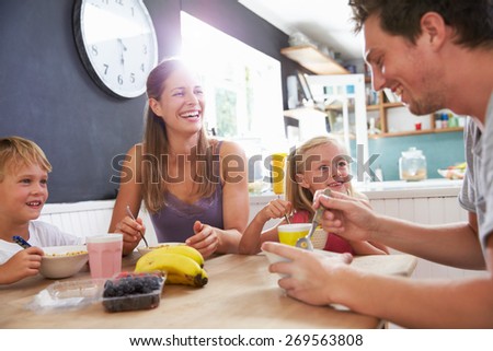 Family Eating Breakfast At Kitchen Table