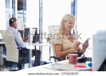 Woman using smart phone in an office