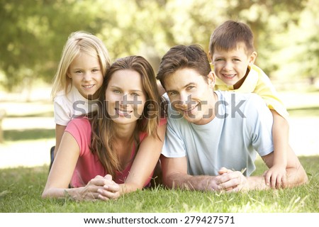 Young Family Relaxing Together In Park