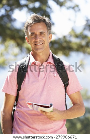 Middle Aged Man Hiking Through Countryside