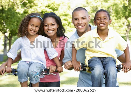 Young African American Family Cycling In Park