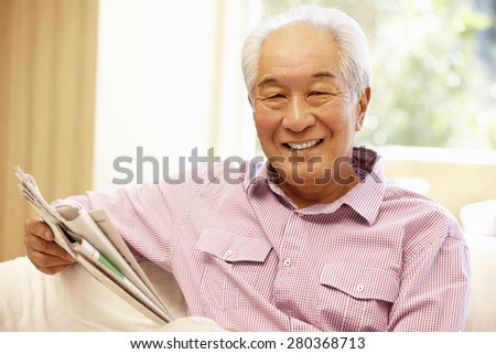 Senior Asian man reading newspaper