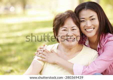 Asian mother and adult daughter portrait outdoors