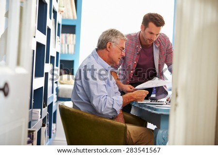 Son Giving Senior Parent Financial Advice In Home Office