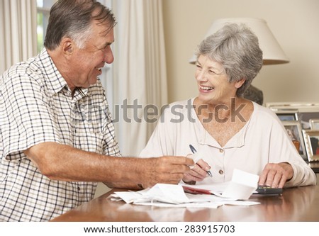 Senior Couple Checking Finances And Going Through Bills Together