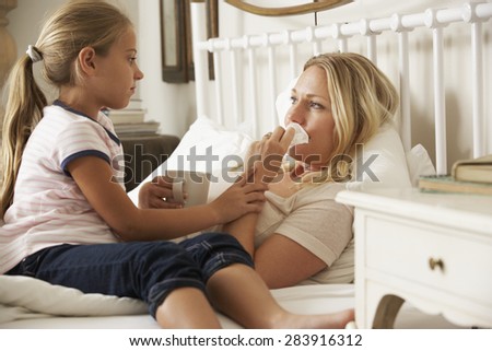 Daughter Visiting Sick Mother In Bed At Home