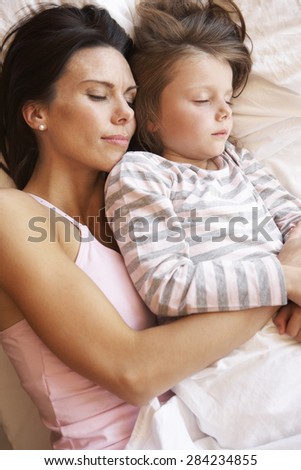 Mother And Daughter Sleeping In Bed