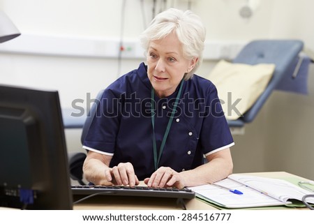 Female Nurse Working At Desk In Office