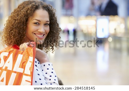 Excited Female Shopper With Sale Bags In Mall