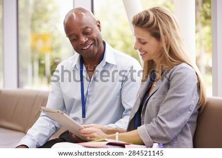 Two College Tutors Looking At Digital Tablet