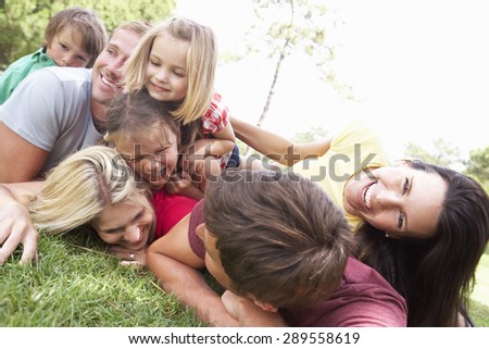 Two Families Playing In Park Together