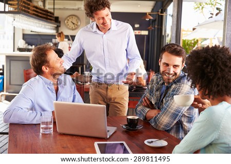 Restaurant manager talking to customers at their table