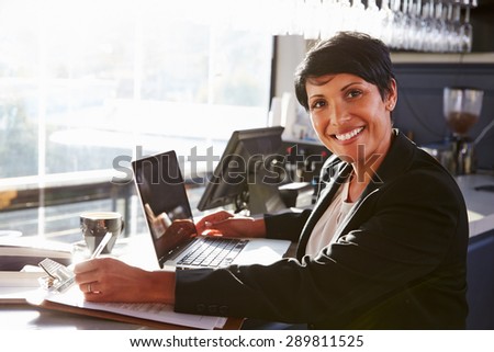 Female restaurant manager working at counter