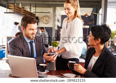 Businessman making credit card payment in a cafe