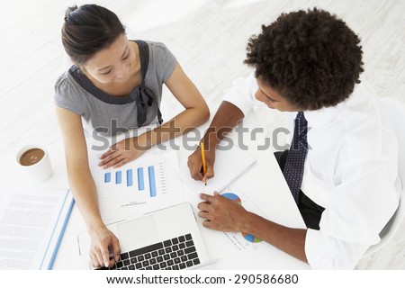 Overhead View Of Businesswoman And Businessman Working At Desk Together