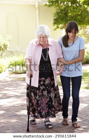 Teenage Granddaughter Helping Grandmother Out On Walk