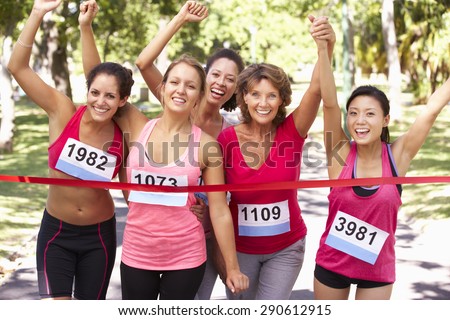 Group Of Female Athletes Completing Charity Marathon Race