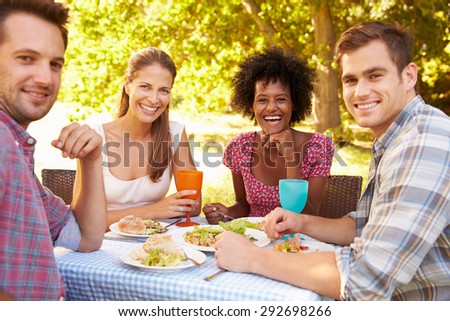 Four friends eating together outdoors