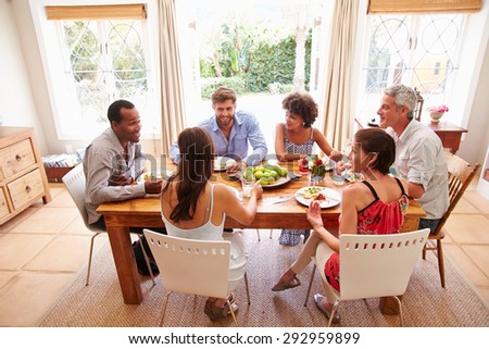 Friends sitting at a table talking during a dinner party