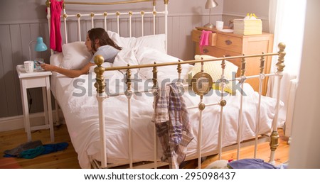 Woman In Bed Woken By Alarm On Mobile Phone