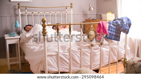 Young Couple Lying Asleep In Bedroom Together