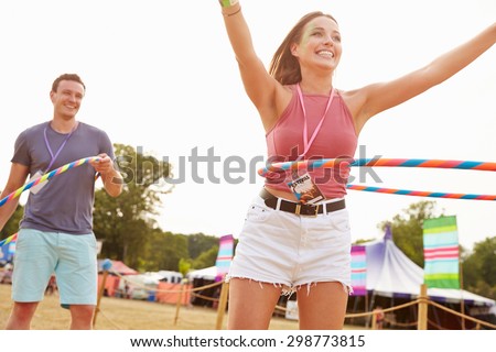 Man and woman dancing with hula hoops at a music festival
