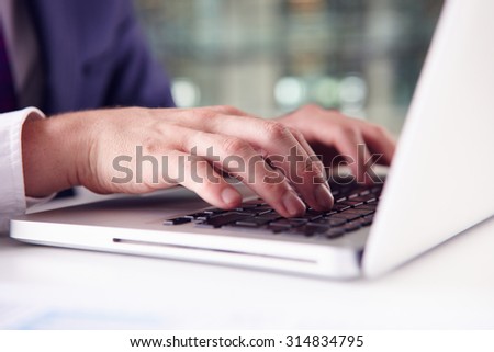 Close up of businessman?s hands using the keypad of a laptop