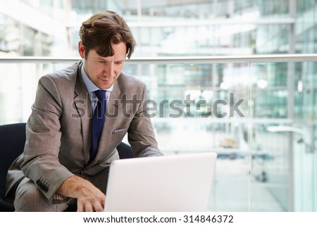 Corporate businessman using laptop computer, waist up