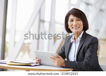 Asian businesswoman with digital tablet,  smiling to camera