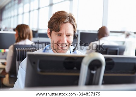 Male call centre worker, looking at screen, close-up