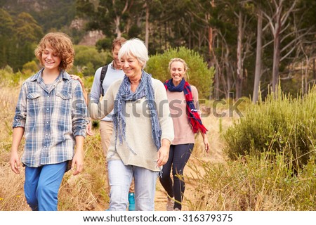 Family with grandmother walking through a forest together