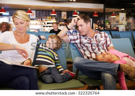 Family In Airport Departure Lounge Wait For Delayed Flight